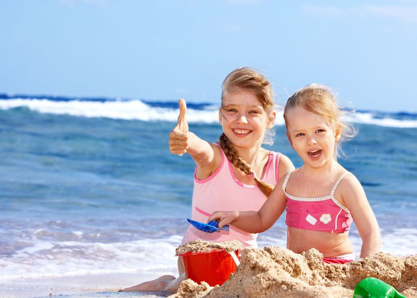 kids on the beach with their divorced parents taking the photo